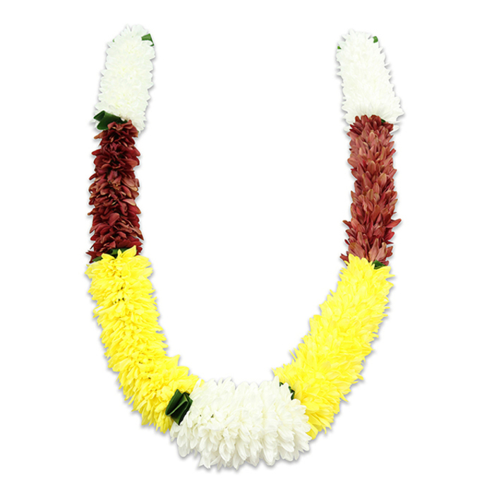 Against a clean white background, this U-shaped decorative garland reads like a carefully composed story in three colours. Each arm starts with a dense, cylindrical section of creamy white, the tightly clustered petals forming a soft, cloud-like texture that suggests small chrysanthemums or cultivated jasmine. Directly beneath that, a compact maroon band introduces a deeper, almost earthen tone - a reverent counterpoint to the luminous whites - and the design then unfurls into a long, vibrant yellow section that forms the broad, graceful arc of the 'U', its plush petals evoking marigold warmth in fabric form. At the very bottom centre, a wide, abundant cluster of white flowers creates a quiet focal point, a visual pause accented with small dark green leaf-like separators that mark the transitions between colour fields. The artificial petals reveal careful handcraft in their repetition and density; soft studio lighting shows hundreds, perhaps thousands, of individual fabric edges and stitches that together produce a weighty, tactile appearance. Functionally and symbolically, this mala is suited to sacred rites and celebratory rites alike - ideal for Hindu pooja, temple offerings, wedding stages, or festival décor during Diwali or Holi. As someone who has prepared garlands for local Byfleet ceremonies and market stalls near the village centre, I can say the colour palette here - white for purity, yellow for prosperity, maroon for devotion - was chosen with both tradition and durability in mind, meant to endure handling and to read clearly from a distance during processions or offerings.